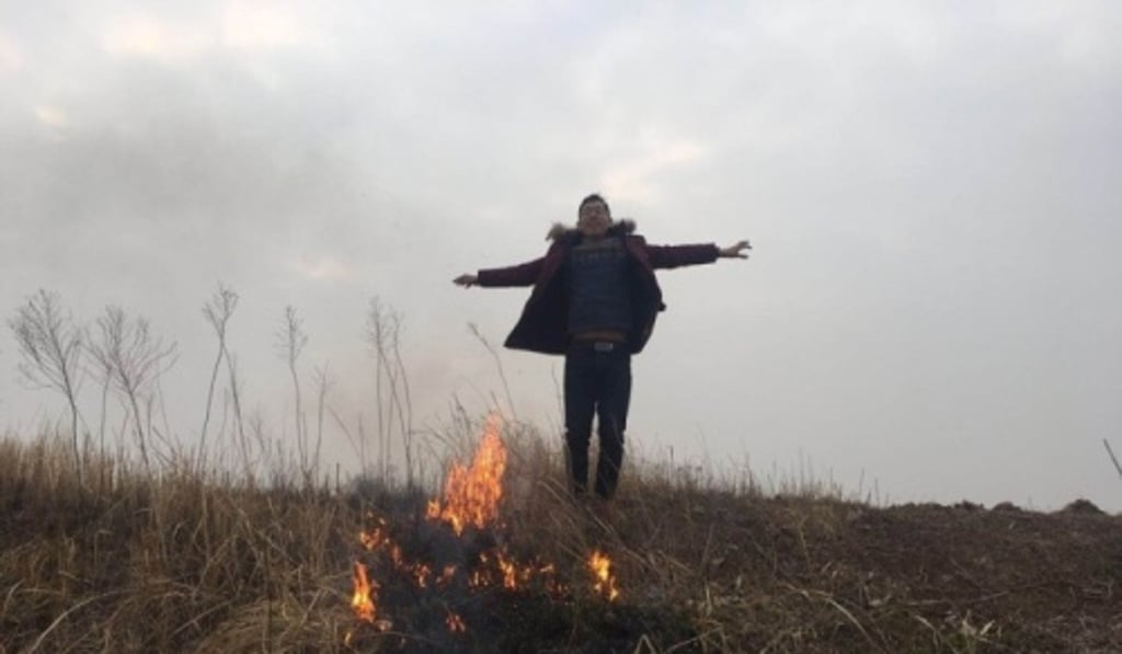 One of the men jumps in the air next to burning undergrowth. Photo: Guancha.cn