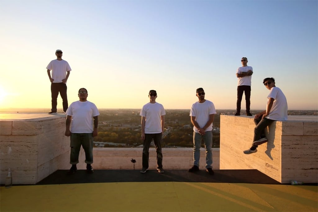 The six young street artists on the rooftop of Fendi’s Rome offices, while creating the mural ‘The Ring of The Future’.