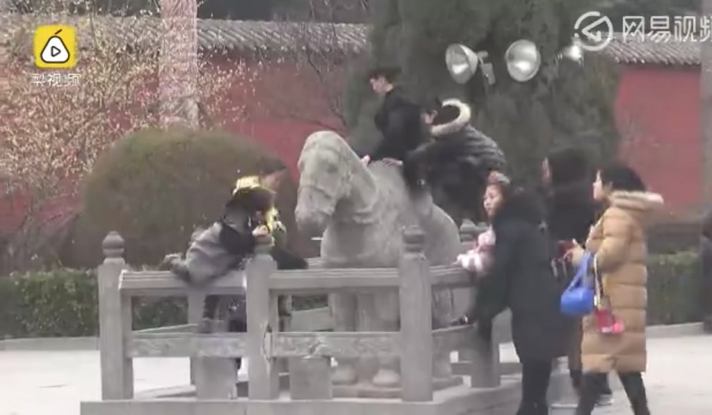 More tourists climbing on one of the statues. Photo: 163.com