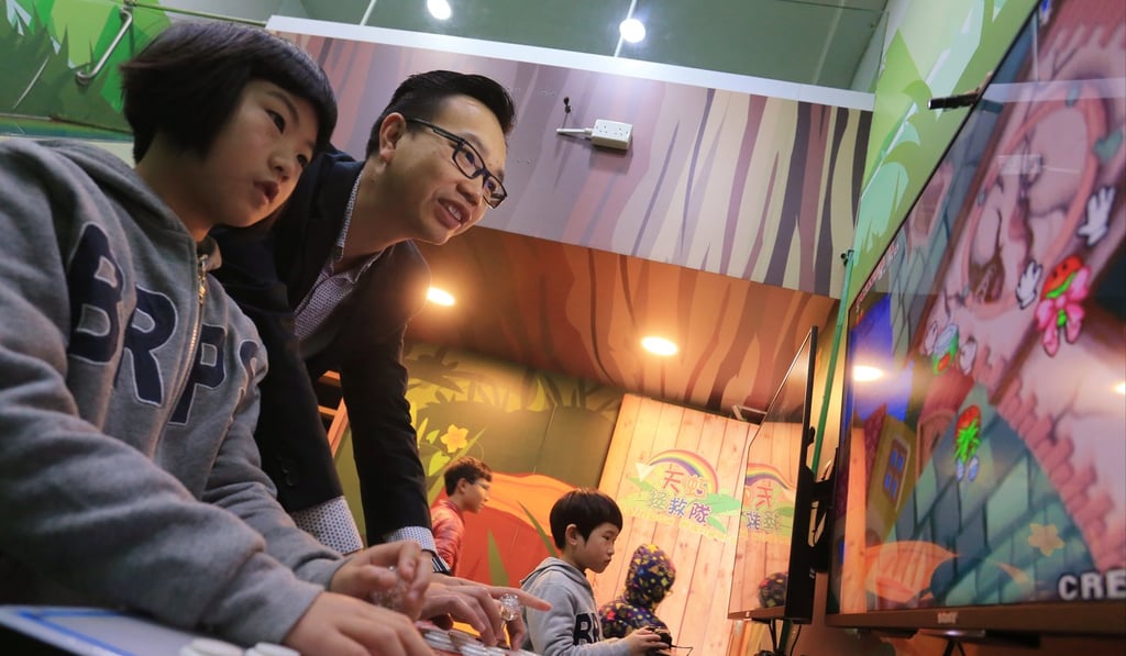 Chu Tsz-wing (second from left), principal of Baptist Rainbow Primary School, plays a video game with pupil Abby Lei Tin-wen, 10. Photo: Dickson Lee Chu Tsz-wing (second from left), principal of Baptist Rainbow Primary School, plays a video game with pupil Abby Lei Tin-wen, 10. Photo: Dickson Lee