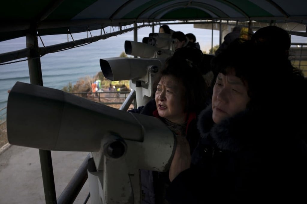 Visitors use binoculars to view North Korea from the Goseong Unification Observatory. Photo: AP