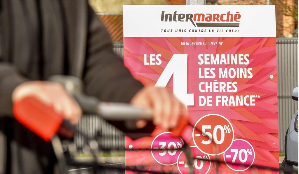 A person walks past an advert for the “Four cheapest weeks of France” at an Intermarche supermarket in Bailleul on February 1. Photo: Agence France-Presse