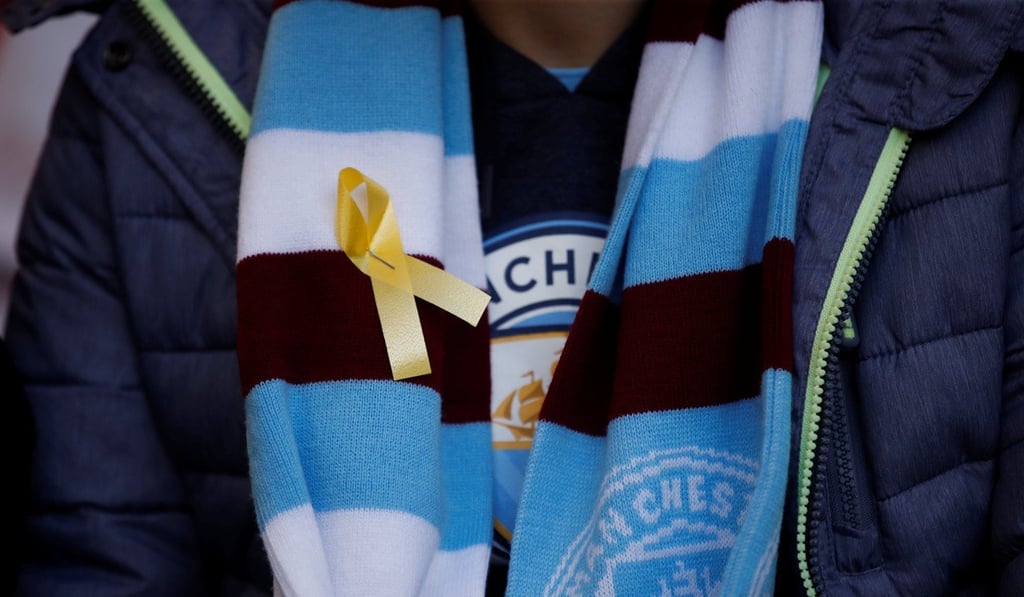 A Manchester City fan wears a yellow ribbon inside the stadium before the League Cup final. Photo: Reuters