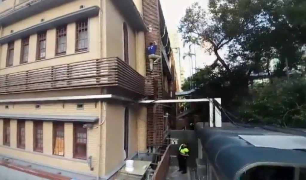 This image taken from video footage shows retired colonel Miao Te-sheng climbing a building in the parliament compound during a protest against the government’s pension reform plan. Photo: Handout This image taken from video footage shows retired colonel Miao Te-sheng climbing a building in the parliament compound during a protest against the government’s pension reform plan. Photo: Handout