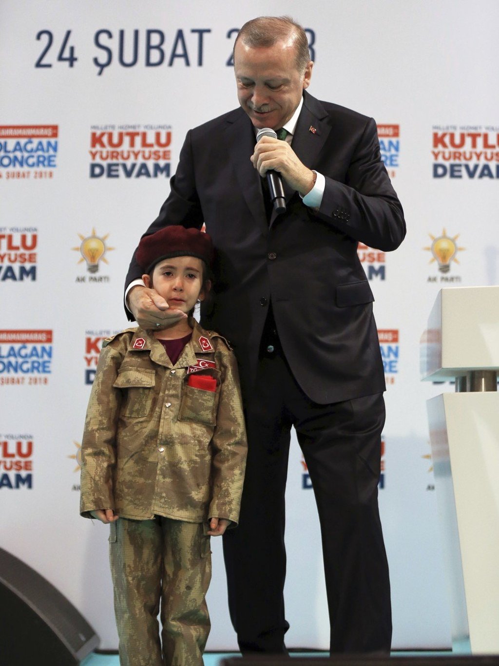 Turkish President Recep Tayyip Erdogan holds Amine Tiras, a young girl in military uniform as he speaks to his ruling party members, in Kahramanmaras, Turkey, on Saturday. Photo: AP