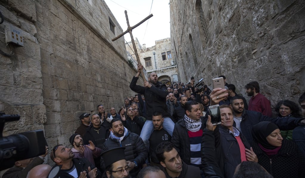 A Christian worshipper holds a wooden cross at a protest next to the closed doors of the Church of the Holy Sepulchre in the Old City quarter of Jerusalem. Photo: EPA A Christian worshipper holds a wooden cross at a protest next to the closed doors of the Church of the Holy Sepulchre in the Old City quarter of Jerusalem. Photo: EPA