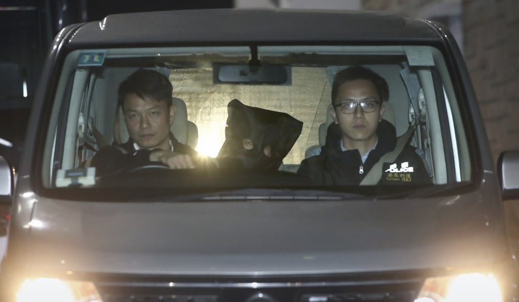 The suspected robber was hooded and escorted by police after being arrested on Wednesday. Photo: Edward Wong The suspected robber was hooded and escorted by police after being arrested on Wednesday. Photo: Edward Wong