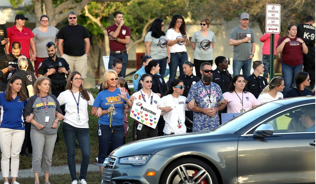 Local residents show their support as students arrive at Marjory Stoneman Douglas High School for the first time since the mass shooting in Parkland, Florida, on Tuesday. Photo: Reuters