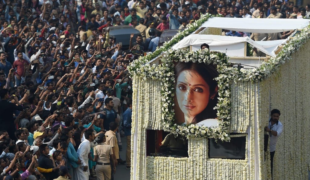 Fans watch the funeral procession of the Bollywood actress Sridevi Kapoor pass through Mumbai. Photo: AFP