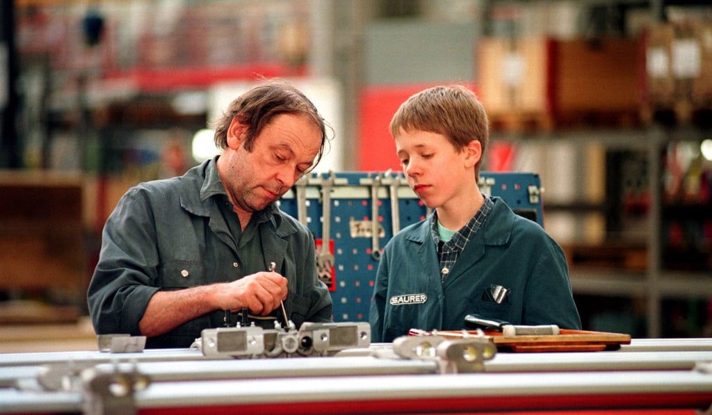 An apprentice and worker at a Swiss machine plant. Photo: Alamy