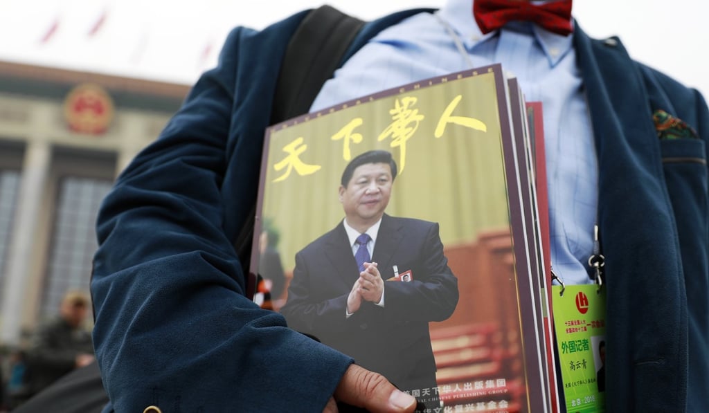 A journalist carrying a magazine with Chinese President Xi Jinping on its front cover. Photo: EPA