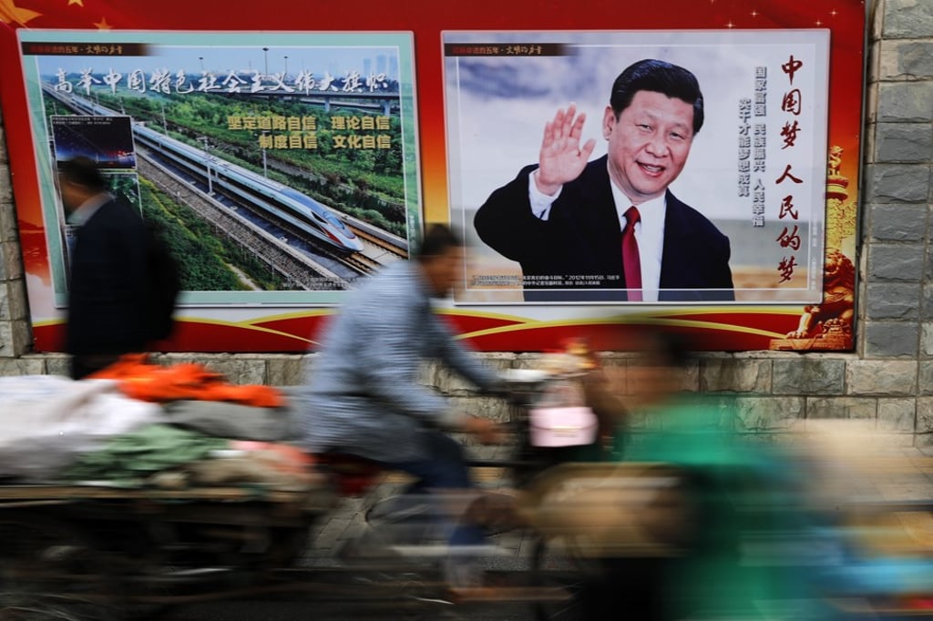 A tricycle carts past a poster featuring Chinese President Xi Jinping, along a street in Beijing on Thursday, Oct. 26, 2017. Photo: AP/Andy Wong