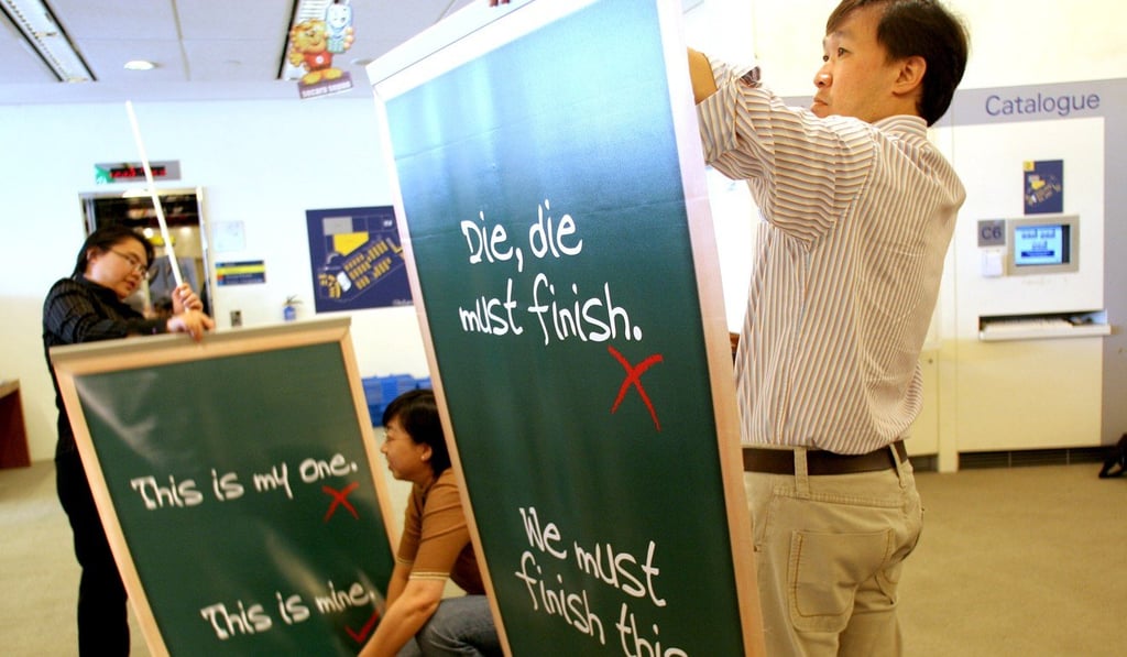 Library staff set up signs to promote proper English speaking in Singapore. Photo: AP