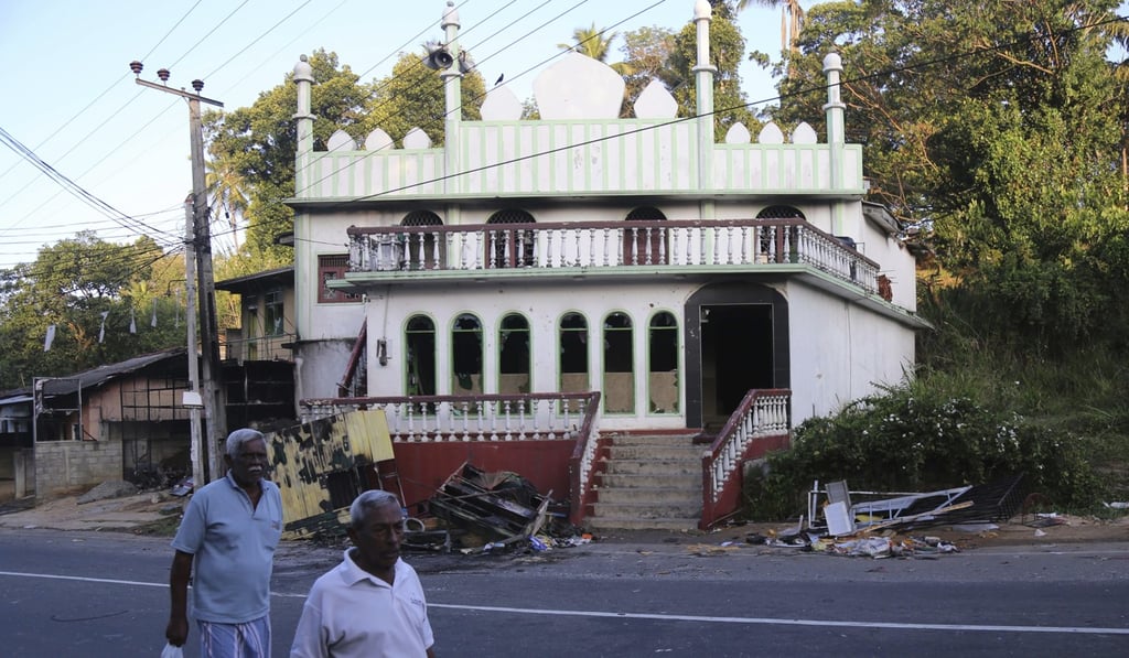 Sri Lankans walk past a vandalised Mosque in Digana, Sri Lanka. The president declared a state of emergency on Tuesday amid fears that anti-Muslim attacks in several central hill towns could spread. Photo: AP Sri Lankans walk past a vandalised Mosque in Digana, Sri Lanka. The president declared a state of emergency on Tuesday amid fears that anti-Muslim attacks in several central hill towns could spread. Photo: AP