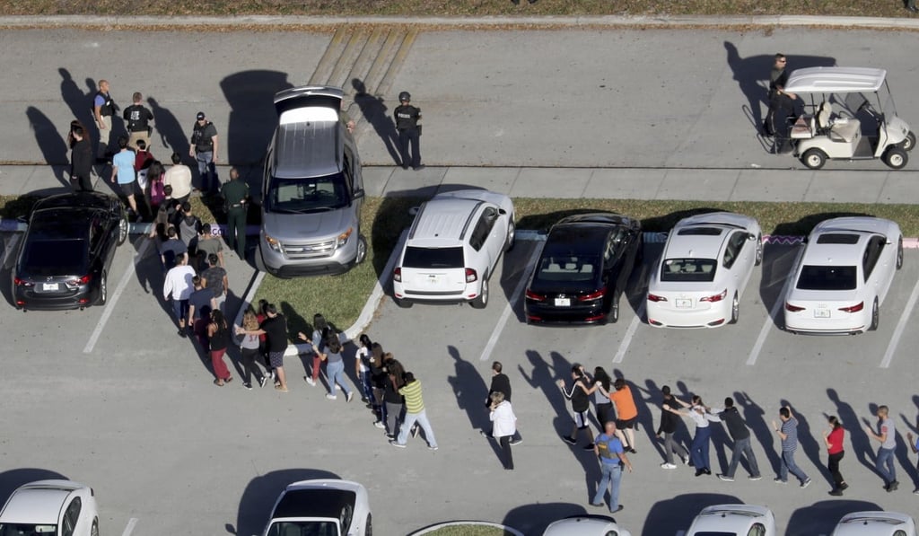 In this February 14, file photo, students are evacuated by police from Marjory Stoneman Douglas High School in Parkland, Florida, after a shooter opened fire on the campus, killing 17 people. Photo: AP