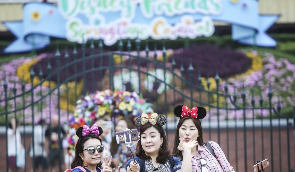 Guests take photos at the entrance of Hong Kong Disneyland. The park posted a loss of HK$345 million in 2017. Photo: Sam Tsang