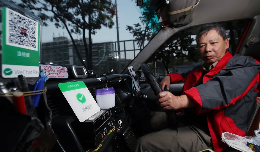 A taxi driver uses WeChat Pay in Mong Kok. Photo: Edward Wong