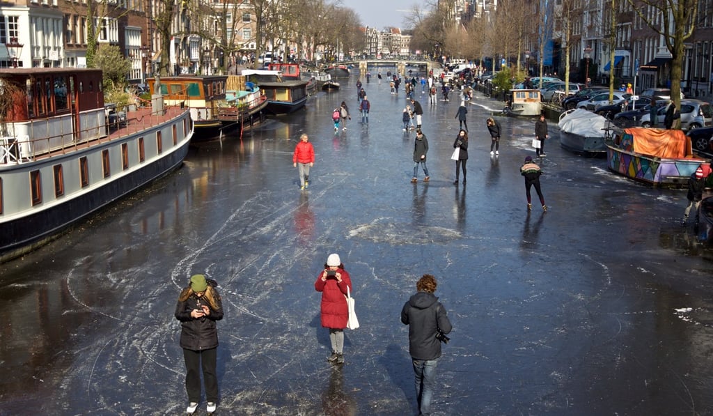 People walk on the frozen Prinsengracht canal after several days of cold temperatures in Amsterdam, the Netherlands, on March 2, 2018. Photo: Xinhua