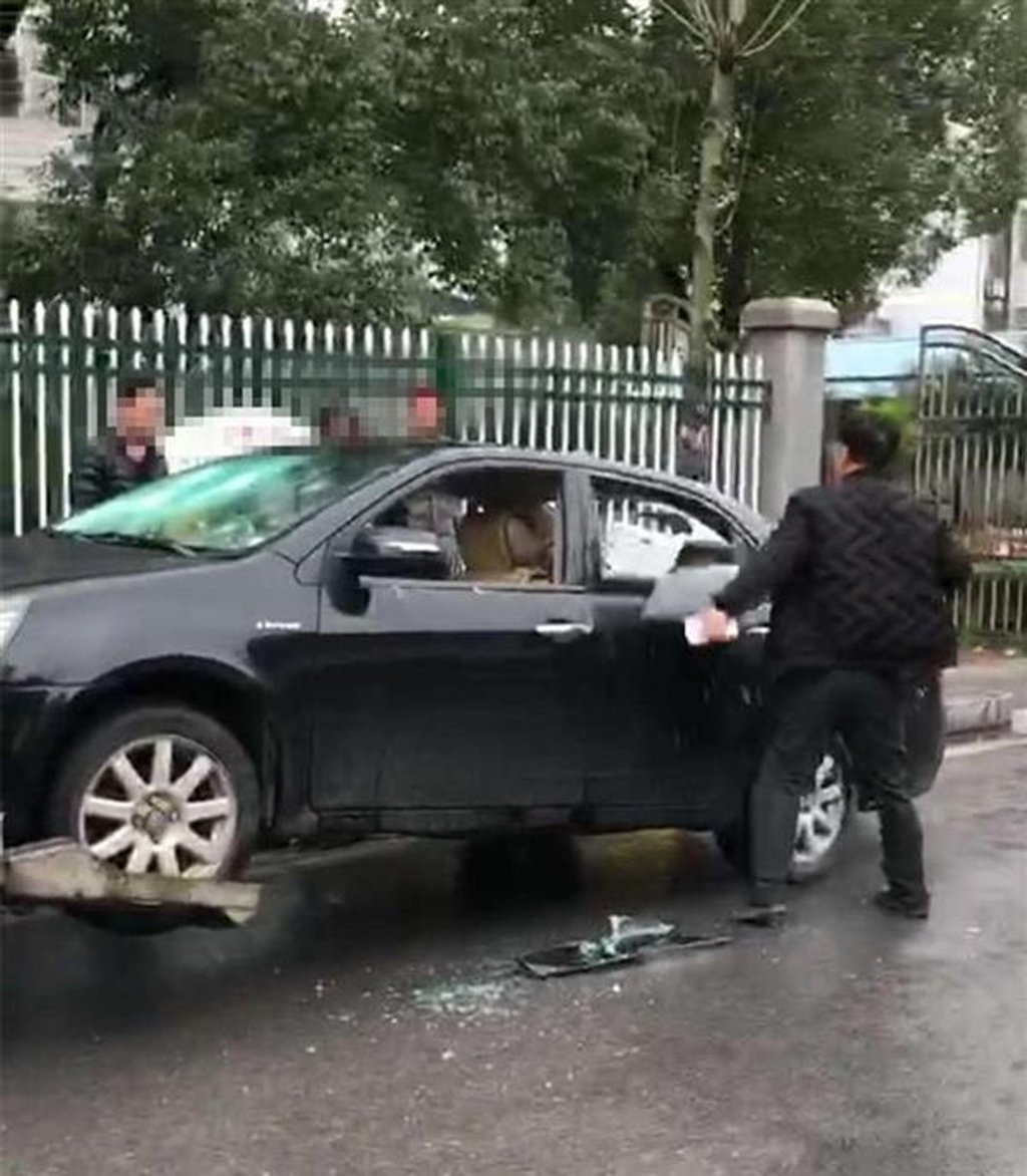 The frustrated motorist delivered several blows to the car’s bodywork and smashed its windows. Photo: Thepaper.cn The frustrated motorist delivered several blows to the car’s bodywork and smashed its windows. Photo: Thepaper.cn