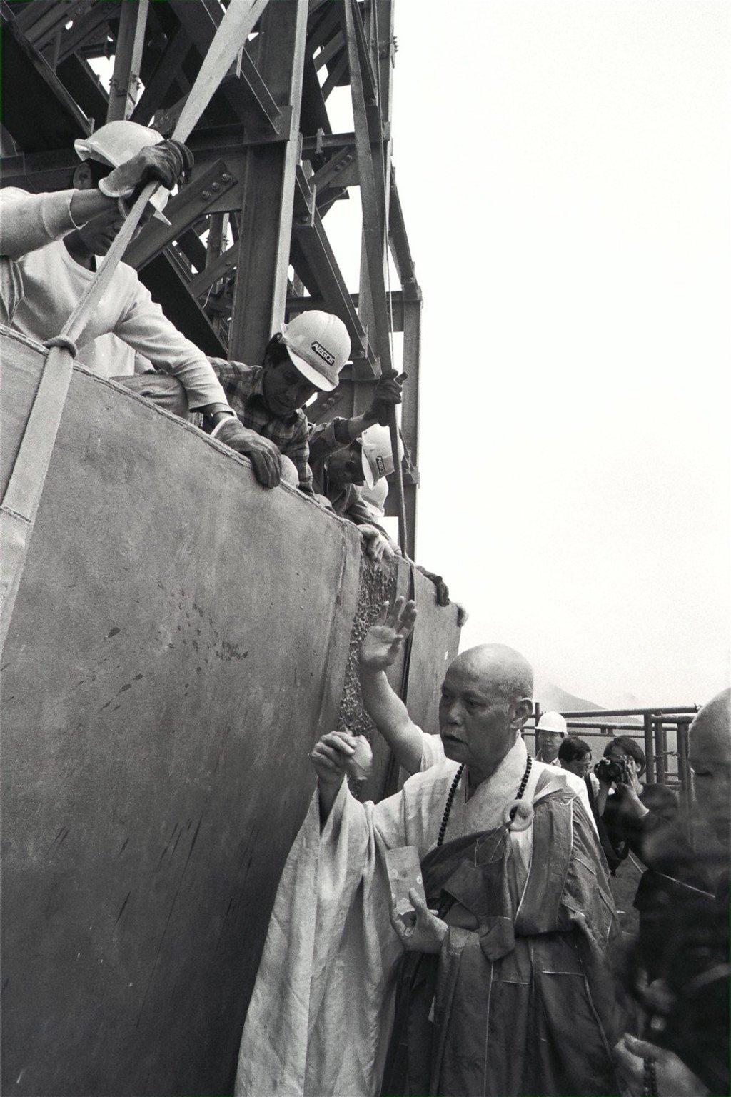 A monk at the Po Lin Monastery blesses the first bronze plate before it is fixed to the framework of the Buddha statue.