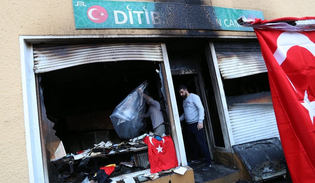 Two men clean up in the entrance of the Koca Sinan Camii mosque after is was destroyed by an arson fire in Berlin, Germany, on March 11, 2018. Photo: EPA-EFE