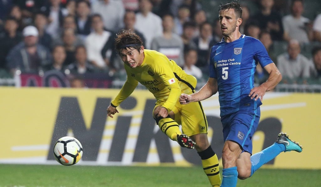 Kashiwa Reysol’s Yusuke Segawa goes for a shot as Kitchee’s Helio Goncalves looks on.