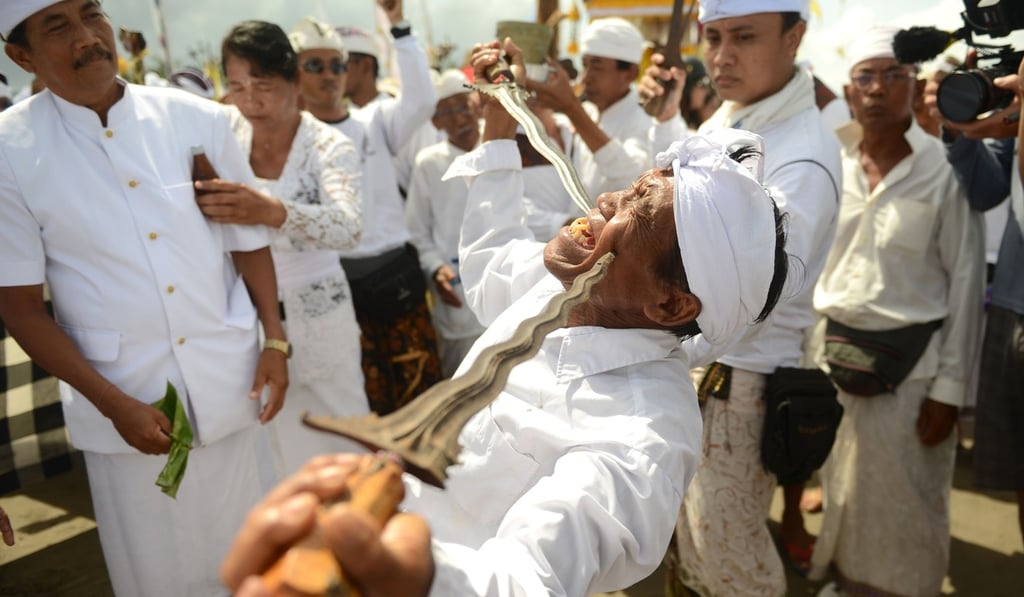 A Balinese man in a trance holds daggers to his cheeks during a Melasti ceremony prayer in Bali, ahead of Nyepi, the Day of Silence. Photo: AFP A Balinese man in a trance holds daggers to his cheeks during a Melasti ceremony prayer in Bali, ahead of Nyepi, the Day of Silence. Photo: AFP