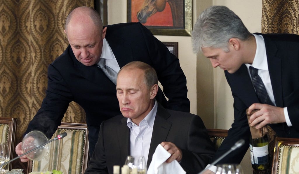 Yevgeny Prigozhin (left) is seen in November 2011 serving food to then-Russian Prime Minister Vladimir Putin during dinner at Prigozhin's restaurant outside Moscow, Russia. Prigozhin is accused of financially backing Russian meddling in US elections. File photo: Pool via AP.