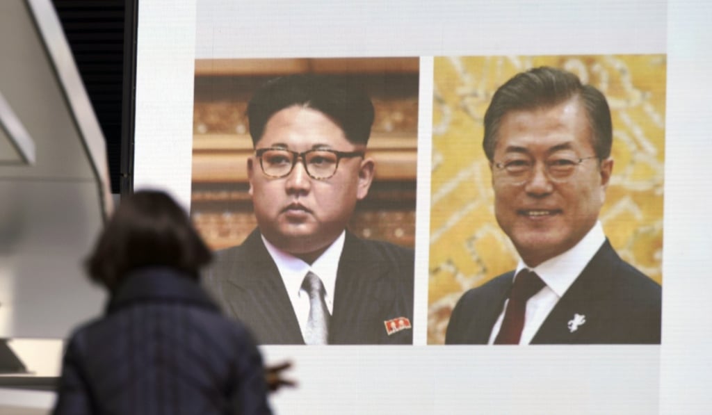 A woman in Tokyo walks past a public TV screen showing photos of North Korean leader Kim Jong-un and South Korean President Moon Jae-in on March 7. The Trump-Kim summit in May is to be preceded by a meeting between the leaders of the two Koreas a month prior, and Japan, wary of North Korea’s threats and its capabilities, will be watching both summits closely. Photo: AP