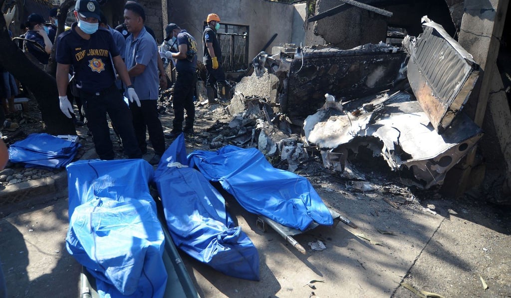 Investigators stand next to bags containing the bodies of the people killed in the crash. Photo: Agence France-Presse Investigators stand next to bags containing the bodies of the people killed in the crash. Photo: Agence France-Presse