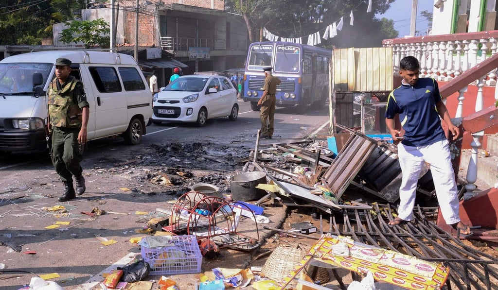 Sri Lankan police commandos patrol next to debris from a damaged shop in the central district of Kandy. Photo: AFP Sri Lankan police commandos patrol next to debris from a damaged shop in the central district of Kandy. Photo: AFP