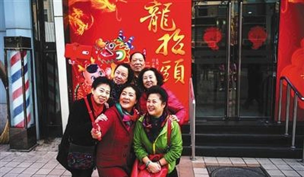 Customers pose for a selfie while waiting for their hair cut. Photo: Beijing News