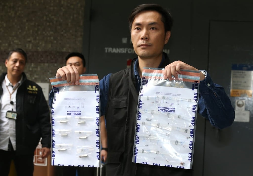 A police officer displays evidence bags containing shell casings found at the flat at Mau Lam House earlier this month. Photo: Dickson Lee