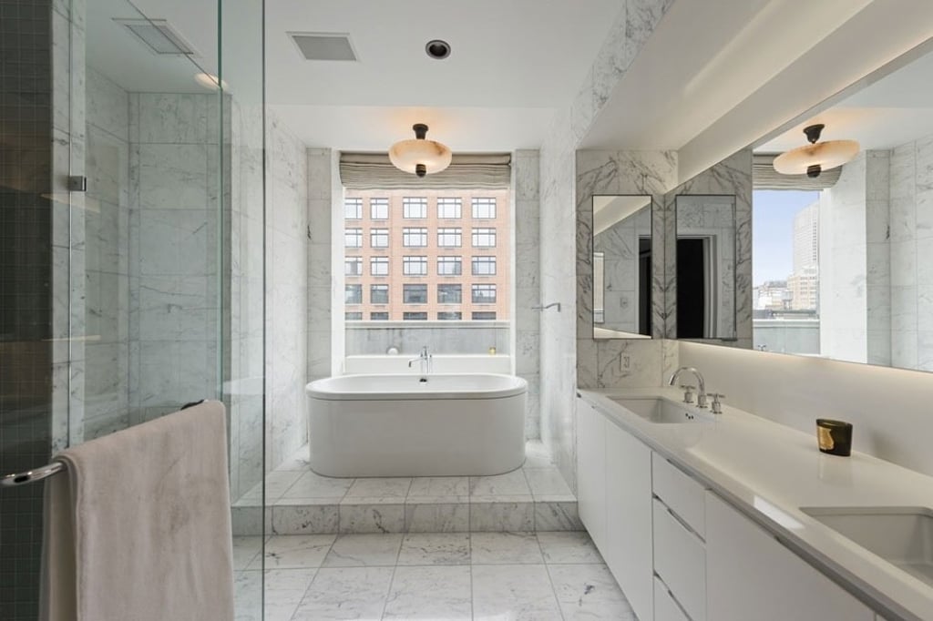 The master bathroom has marble flooring and panels that stretch up to the ceiling. Photo: Stribling & Associates