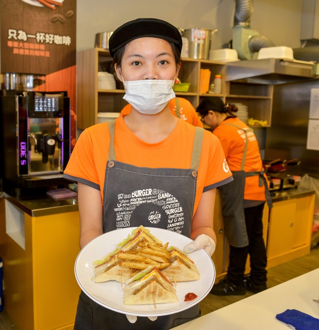 An employee serves sandwiches at a QBurger breakfast bar in northern Taiwan. Photo: Chris Stowers