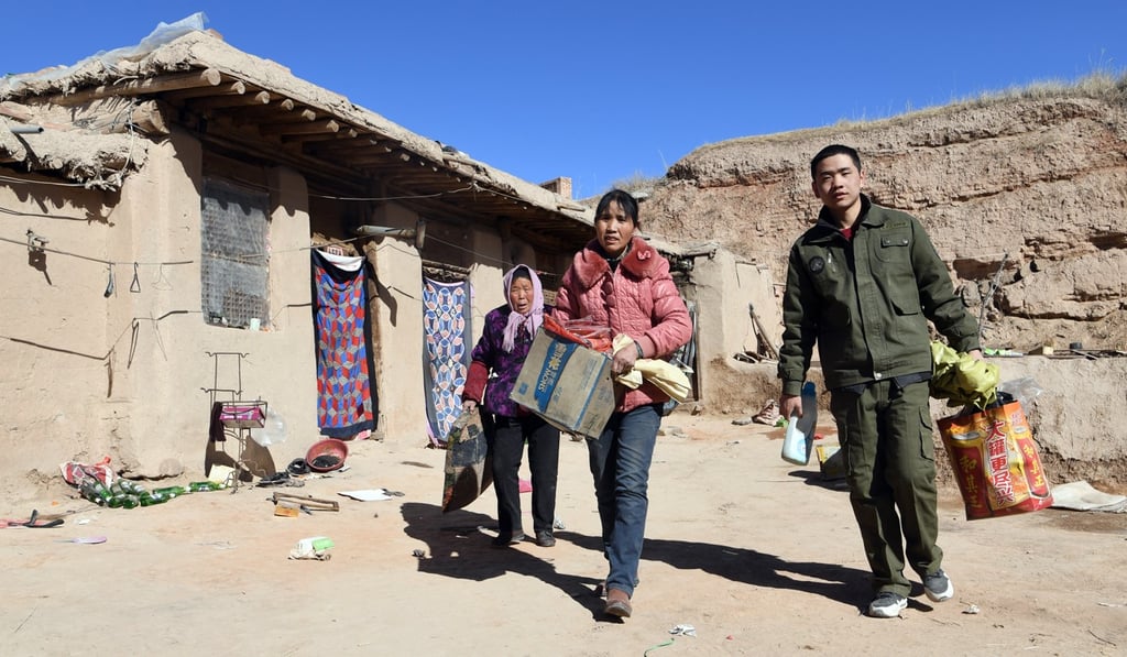 Xu Cun (centre), her mother-in-law Xu Honglian (left) and her son Huang Yubin carry belongings from their old house in Shicheng Village, Gansu province, on February 6. Xu Cun, whose husband’s disability leaves her to support the family, was able to move homes thanks to help from the local government's poverty relief project. Photo: Xinhua