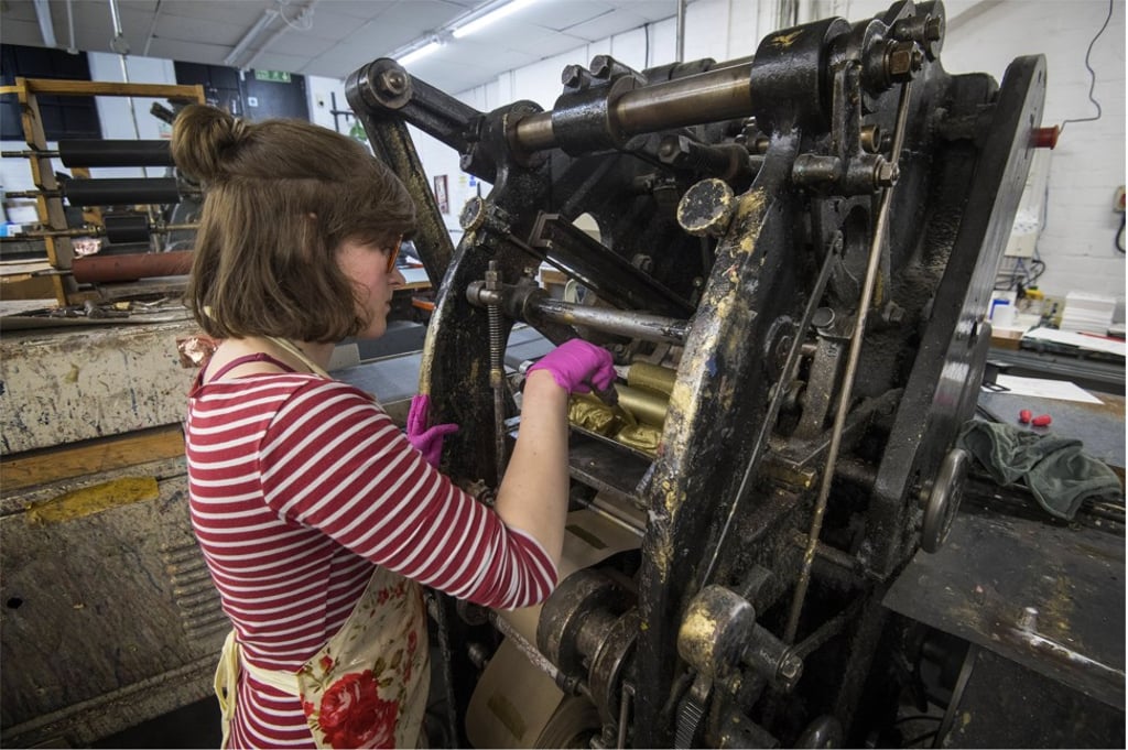 Gold ink is added to the die stamping press at the London workshop of Barnard and Westwood, which is printing the wedding invitations. Photo: EPA