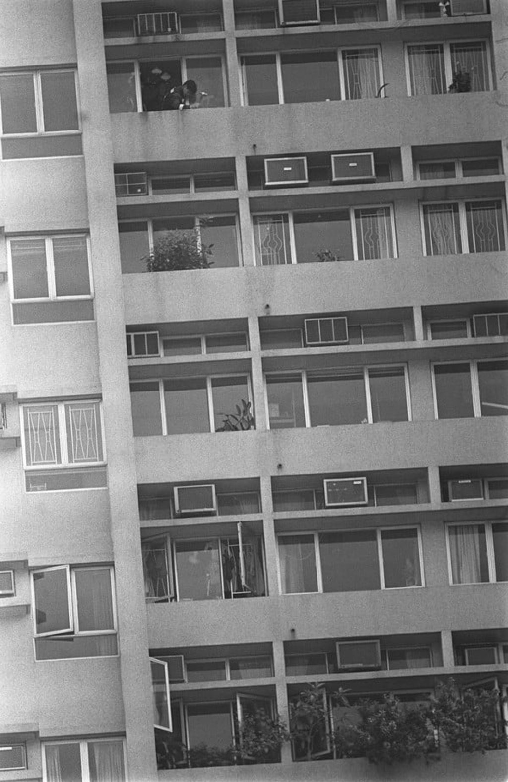 A fireman hammers at the cemented window box containing the bodies. Picture: SCMP