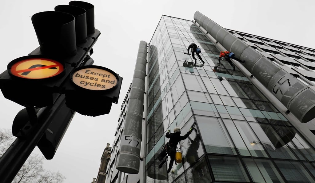 Workers clean the windows of the shared building which houses the offices of Cambridge Analytica in central London on March 24, 2018. British regulators finished searching the offices of Cambridge Analytica, the firm at the centre of a Facebook data scandal, before dawn on Saturday and said they would examine the evidence before considering “next steps”. Photo: AFP Workers clean the windows of the shared building which houses the offices of Cambridge Analytica in central London on March 24, 2018. British regulators finished searching the offices of Cambridge Analytica, the firm at the centre of a Facebook data scandal, before dawn on Saturday and said they would examine the evidence before considering “next steps”. Photo: AFP