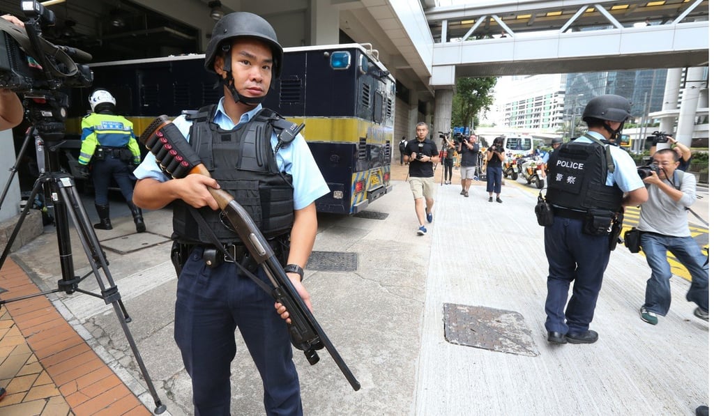A Hong Kong police officer wields a Remington shotgun outside the High Court in this 2016 file photo. Photo: SCMP