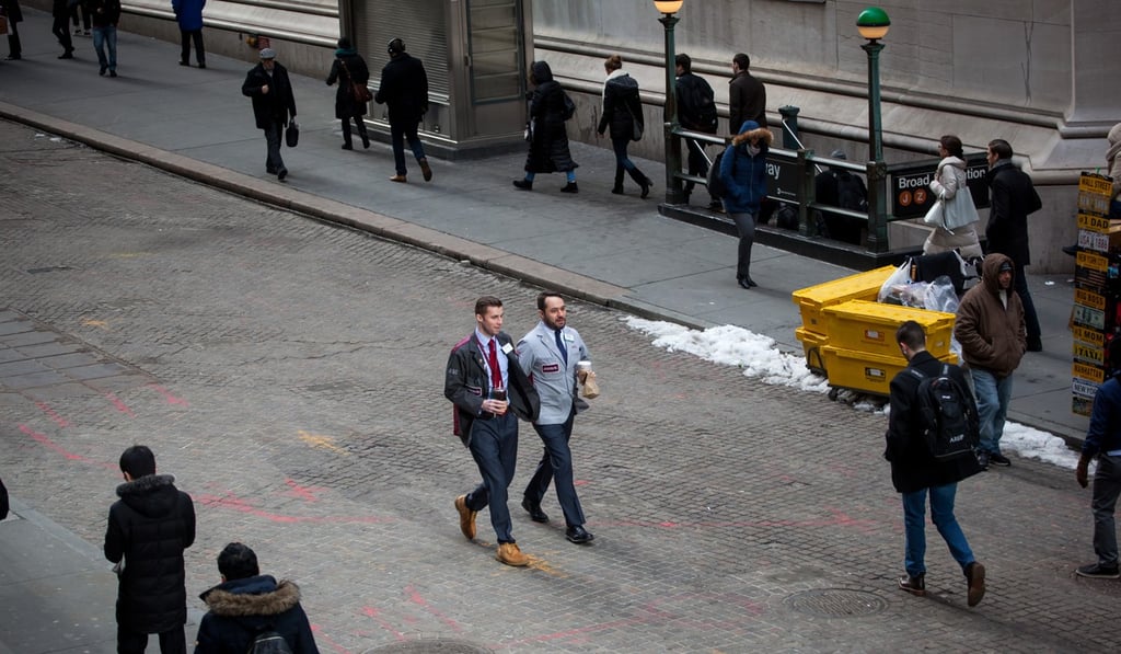 Traders walk down Wall Street in front of the New York Stock Exchange on Friday, March 23. Photo: Bloomberg