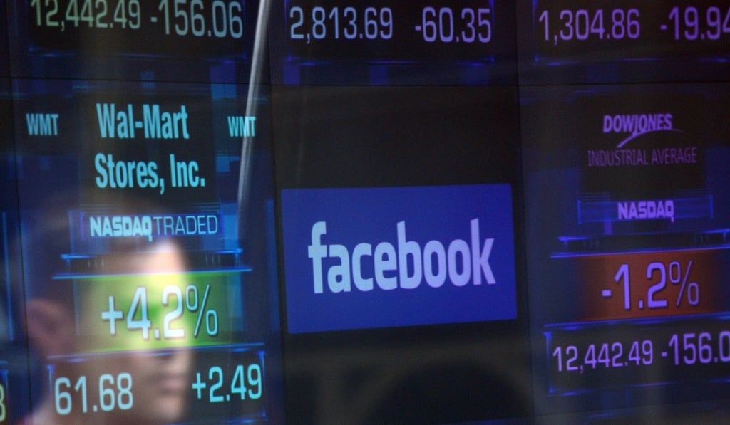 In this file photo taken on May 17, 2012, a Facebook logo is seen through the windows of the NASDAQ stock exchange as people walk by on Times Square in New York. Facebook shares tumbled following reports of a privacy scandal involving Cambridge Analytica. Photo: AFP In this file photo taken on May 17, 2012, a Facebook logo is seen through the windows of the NASDAQ stock exchange as people walk by on Times Square in New York. Facebook shares tumbled following reports of a privacy scandal involving Cambridge Analytica. Photo: AFP