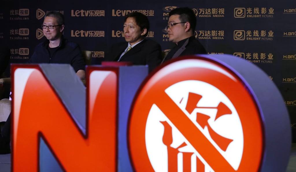 Seen behind an installation symbolising action against copyright violation are (left to right), Youku-Todou CEO Victor Koo, Sohu CEO Charles Zhang and Tencent senior vice-president Seng Yee Lau, during a joint news conference in Beijing in November 2013. Photo: Reuters
