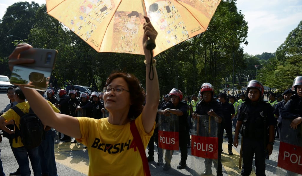 Police stand guard as Bersih supporters protest against a controversial proposal to redraw electoral boundaries outside Parliament House in Kuala Lumpur. Photo: Reuters