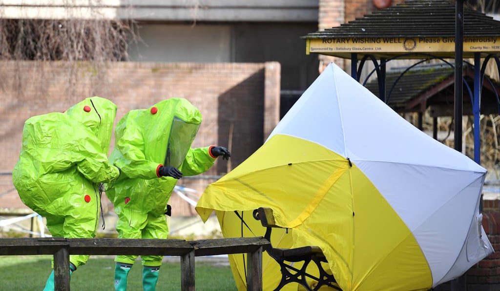 Members of the emergency services in green biohazard suits put a tent over the bench on which the Skripals were found in critical condition on March 8. Photo: AFP