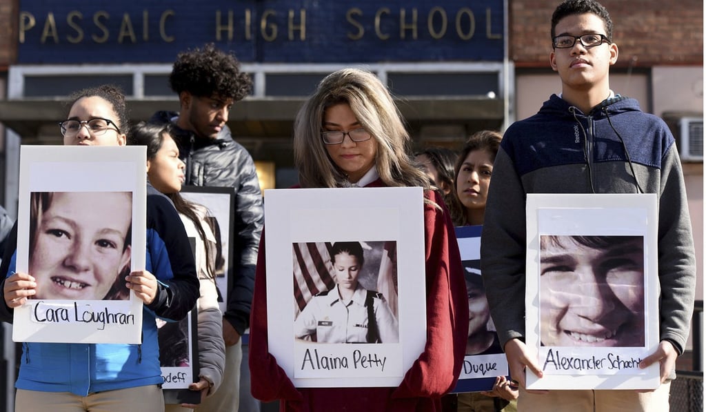 Students from Passaic High School hold photos of some of the 17 victims killed at Marjory Stoneman Douglas High School as they participate in a walkout to protest gun violence on March 14, in Passaic, New Jersey. Photo: AP