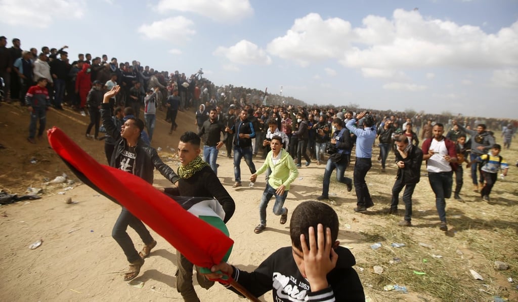 Palestinian protesters react while evacuating a wounded youth during clashes with Israeli troops on Friday. Photo: AP Palestinian protesters react while evacuating a wounded youth during clashes with Israeli troops on Friday. Photo: AP
