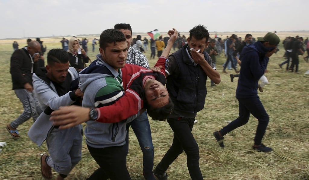 Palestinian protesters evacuate a wounded youth during clashes on Friday. Photo: AP Palestinian protesters evacuate a wounded youth during clashes on Friday. Photo: AP