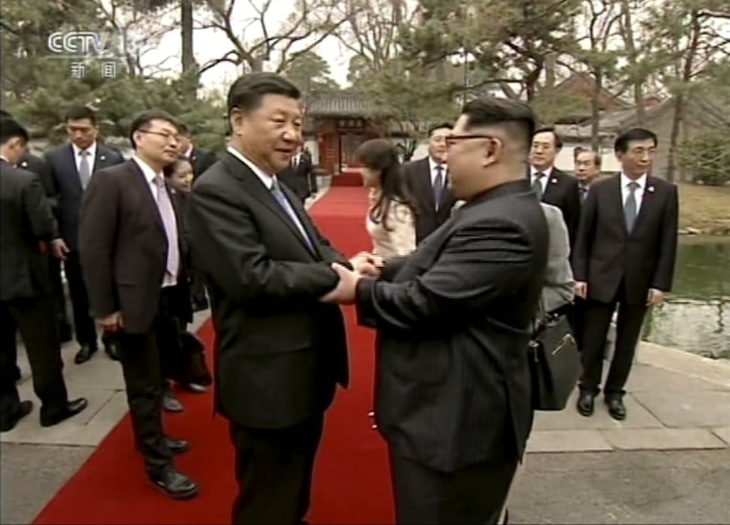 Kim Jong-un (right) shakes hands with Xi Jinping at the Diaoyutai State Guesthouse in Beijing. Photo: CCTV via AP Video