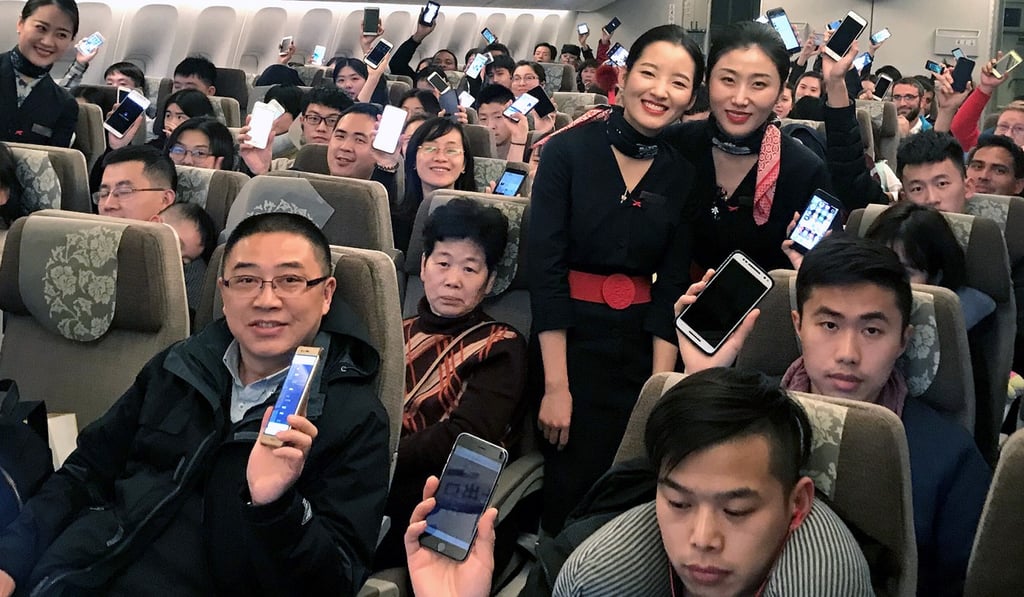 Starting in January, China Eastern Airlines allowed passengers to use smartphones and tablets inflight, but phones still have to be switched to airplane mode. There are more than 750 million mobile phone users in China. Photo: Xinhua